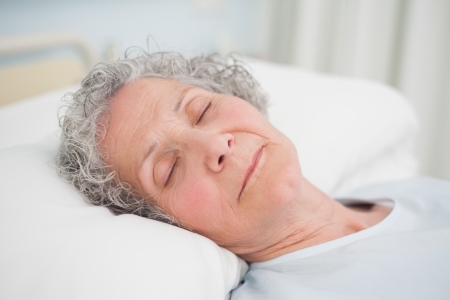 Patient sleeping on a medical bed in hospital wardの写真素材