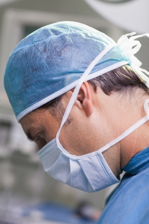 Serious doctor performing surgery in close-upの写真素材