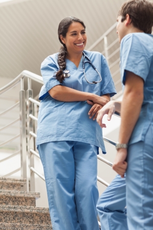 Smiling nurse talking with a colleague in hospital wardの写真素材