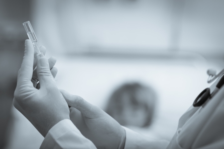 Doctor preparing a syringe in hospital ward in black and whiteの写真素材