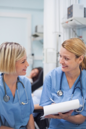 Smiling nurses speaking in hospital wardの写真素材