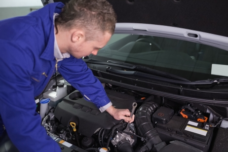 Mechanic repairing the engine with a spanner in a garageの写真素材