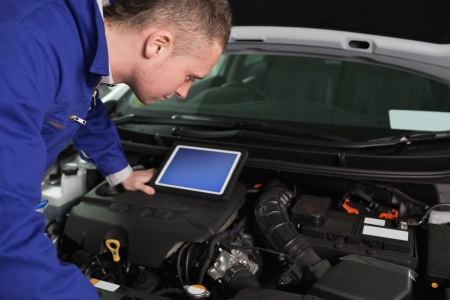 Mechanic checking an engine in a garageの写真素材