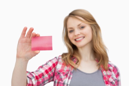 Smiling woman holding a loyalty card against a white backgroundの写真素材