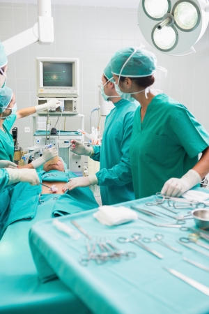 Surgeons checking a monitor while operating in an operating theaterの写真素材