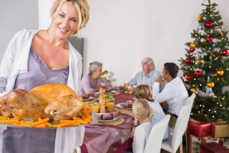 Proud mother showing roast turkey at christmasの写真素材
