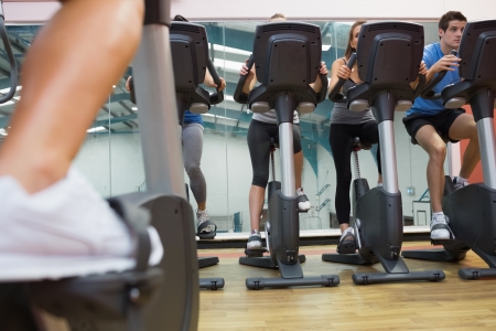 Four people taking a spinning class at the gymの写真素材