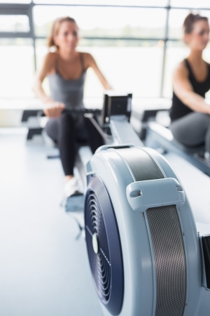 Rowing machine being used by woman in gymの写真素材