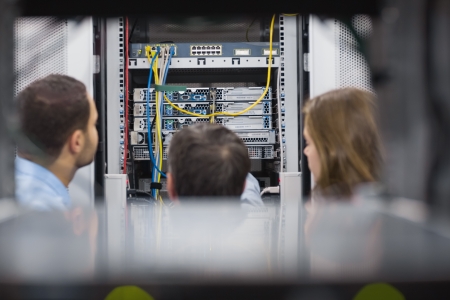 Technicians viewing a server while standing in hallwayの写真素材