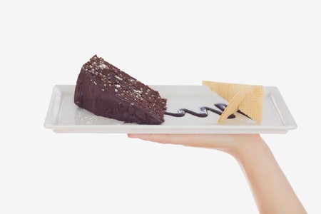 Close-up of hand holding pastry plate over white backgroundの写真素材