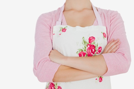 Maid in apron with arms crossed against white backgroundの写真素材