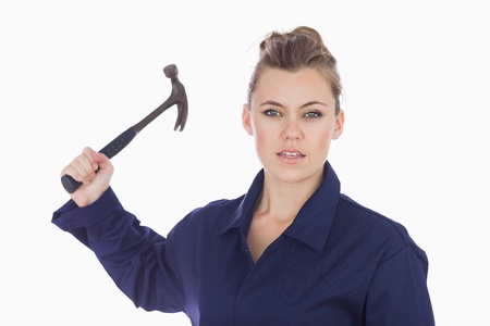 Portrait of young female technician holding claw hammer against white backgroundの写真素材
