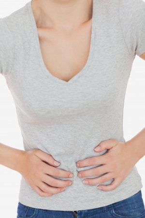 Woman suffering from stomach against white backgroundの写真素材
