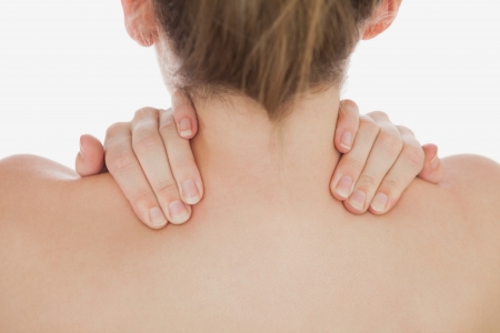 Close-up of of woman massaging neck over white backgroundの写真素材