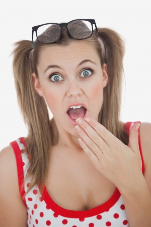 Portrait of amazed young woman with eyes wide open against white backgroundの写真素材