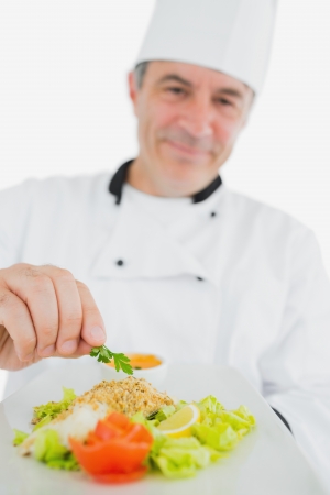 Portrait of male chef presenting fresh prepared meal over white backgroundの写真素材