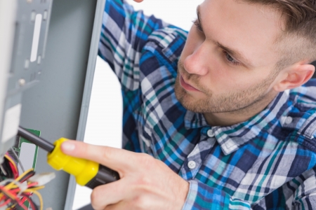 Close-up of young computer engineer working on cpu over white backgroundの写真素材