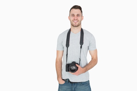 Portrait of male photographer with photographic camera over white background