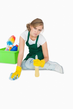 Portrait of young maid cleaning floor over white backgroundの写真素材