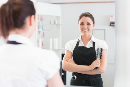 Portrait of a hairdresser with arms crossed in hairdressing salonの写真素材