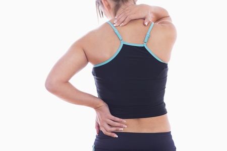 Rear view of sporty young woman massaging neck over white background