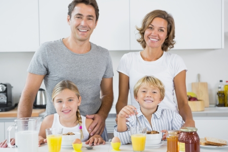 Happy family at breakfast in kitchenの写真素材
