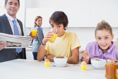 Smiling family at breakfast time in the kitchenの写真素材