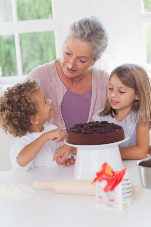 Children making cake with granny in the kitchenの写真素材