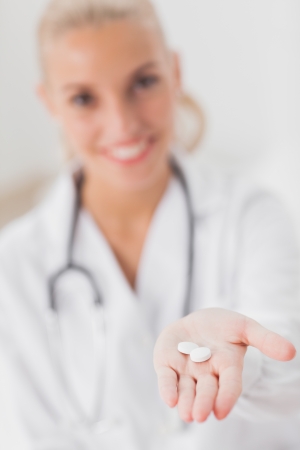 Smiling doctor holding out tabletsの写真素材