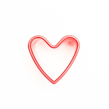 Pink heart shaped cookie cutter on white backgroundの写真素材
