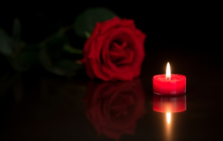 Romantic candle with red rose on black backgroundの写真素材