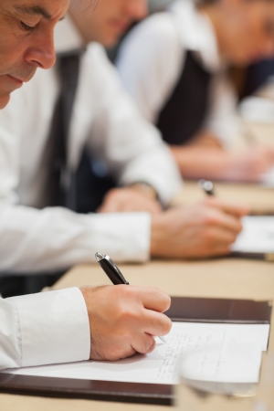 Businessman making notes during meetingの写真素材