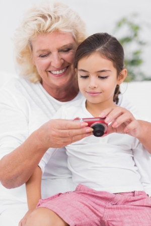 Granddaughter and grandmother looking at pictures on the digital cameraの写真素材