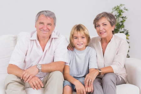 Portrait of a little boy and his grandparents in sitting room