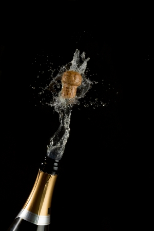 Champagne cork popping on black backgroundの写真素材
