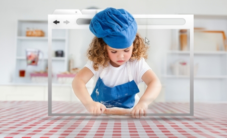 Digital internet window showing girl in cookery gear rolling pastry on kitchen tableの写真素材