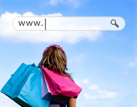Girl holding shopping bags with address bar above against a blue skyの写真素材