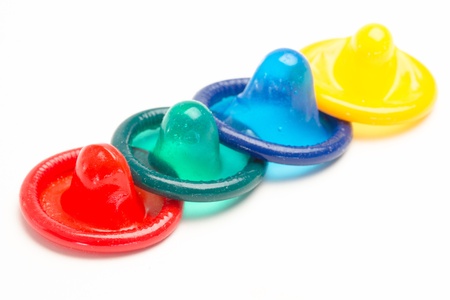 Four colourful condoms on white backgroundの写真素材