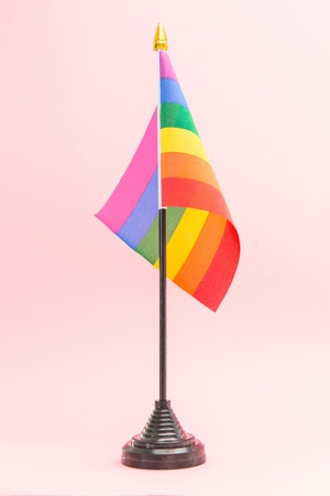 Gay Pride flag on stand on pink backgroundの写真素材