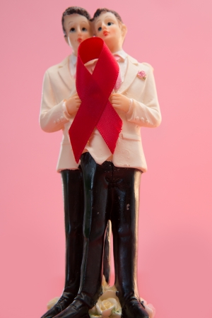 Gay groom cake toppers with aids awareness ribbon on pink backgroundの写真素材