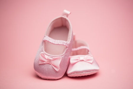 Pink baby booties on pink backgroundの写真素材