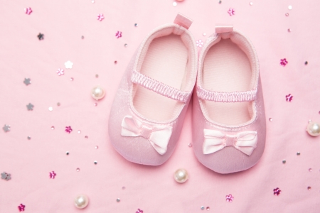 Baby shoes for a girl on pink blanket with pearlsの写真素材