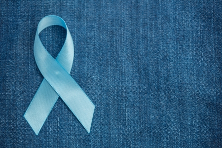 Blue ribbon for prostate cancer awareness on blue demin with copyspaceの写真素材