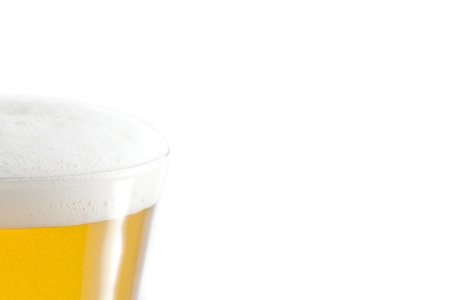 Full glass of beer and foam against a white backgroundの写真素材