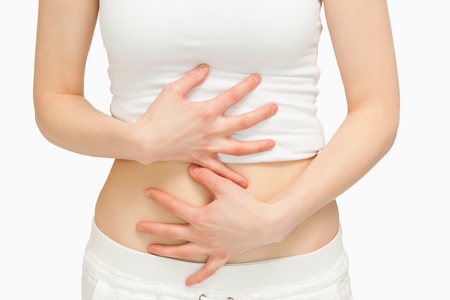 Woman touching her belly with her hands against white backgroundの写真素材
