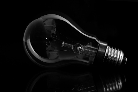 Clear light bulb laying on its side on black background の写真素材