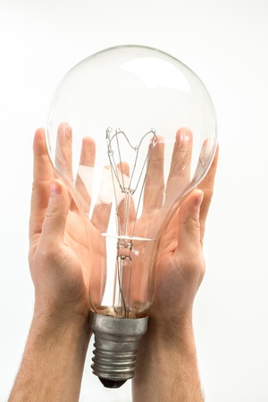 Man holding big light bulb in his hands on white backgroundの写真素材