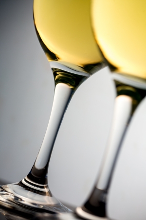 Close up of two white glasses full of white wine on grey backgroundの写真素材