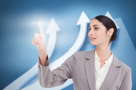 Businesswoman using transparent futuristic interface with arrows backgroundの写真素材
