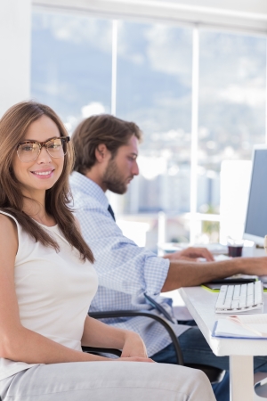 Portrait of smiling designer with colleague at work behind herの写真素材